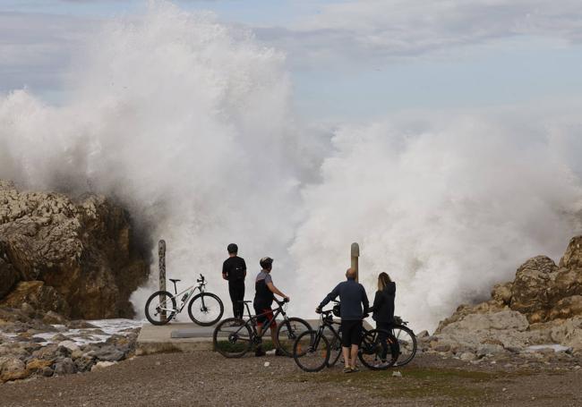 Ciclistas dejándose sorprender por las olas en La Virgen del Mar.