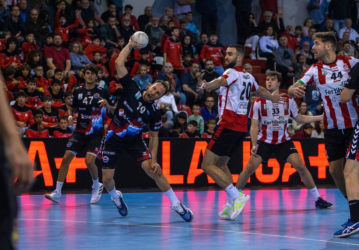 Tioumentsev, del Sinfín, dispara con furia sobre el arco rival ante la mirada de varios rivales y Marc López.