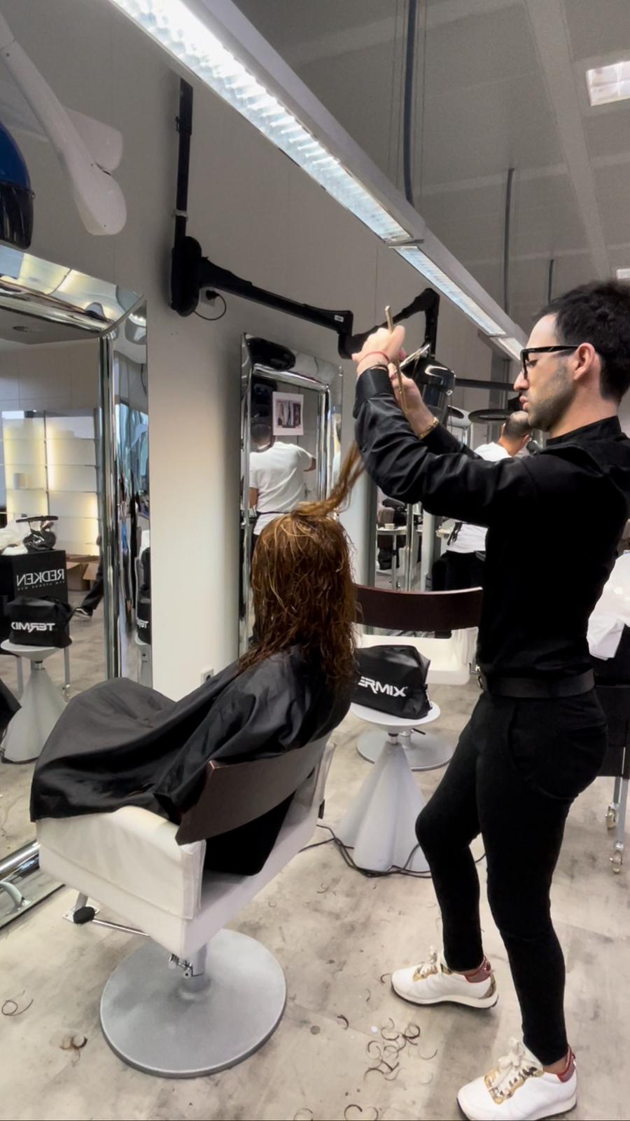 Imagen de su día a día en un salón cortando el cabello de una de sus clientas.