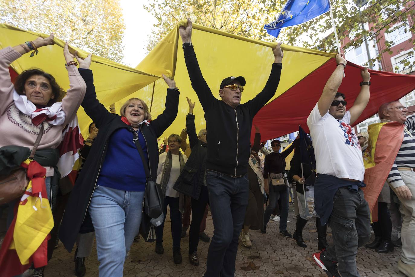 Participantes en la marcha promovida por Vox trasladando la gran bandera