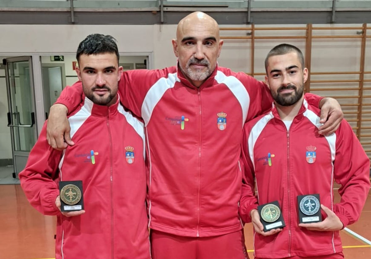 Rubén Múgica con su entrenador Tomás Ramos y Pedro Fernández posando con las medallas.