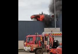 El fuego sale por la chimenea en el incendio de un taller en Colindres