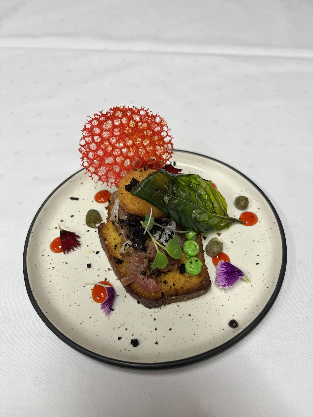 Tartar de tudanca y mantequilla de albahaca sobre tosta de maíz y especias.