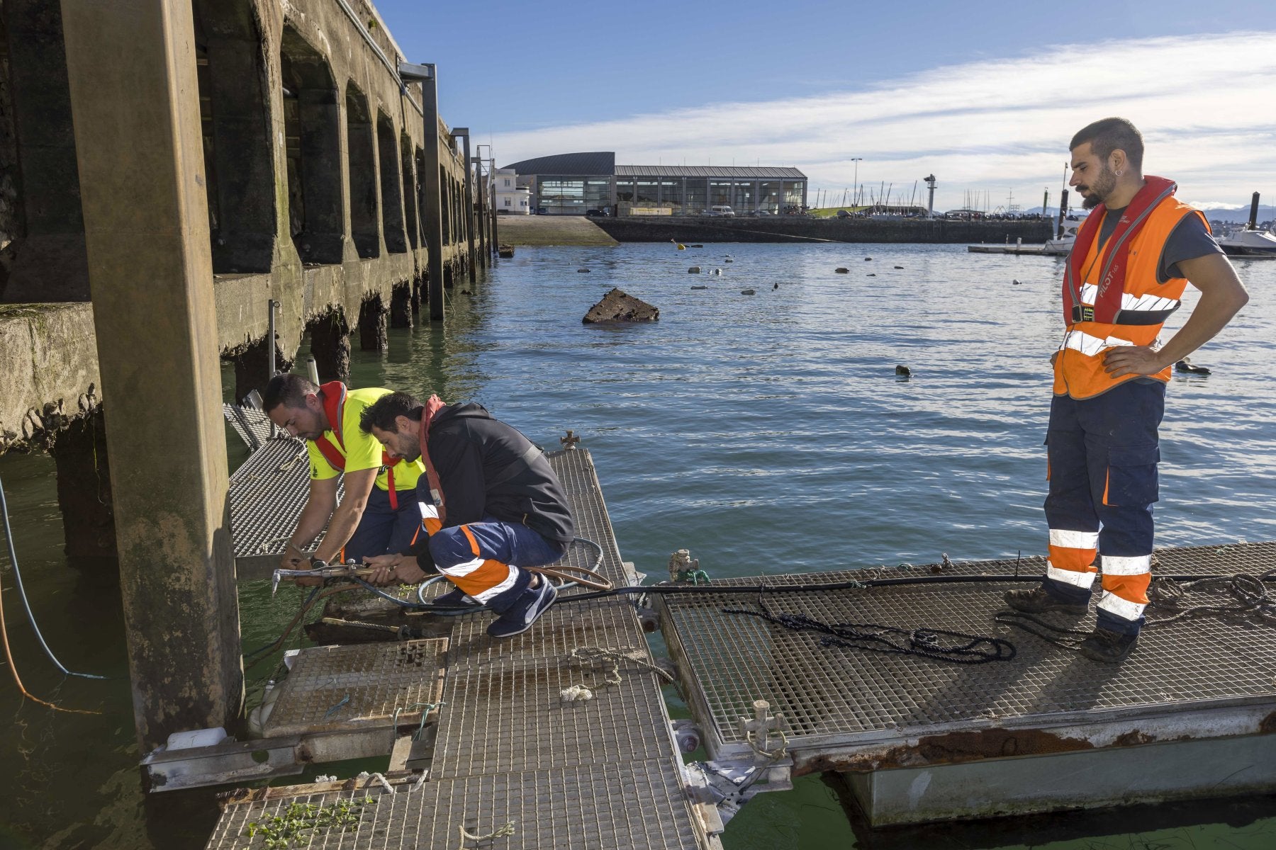 Los operarios desmontan las últimas piezas de los viejos pantalanes de Puertochico.
