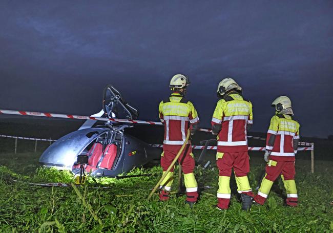 Bomberos junto al helicóptero en la zona del accidente.