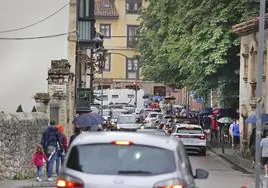 Una de las calles del centro de la villa atestada de vehículos y peatones en verano.