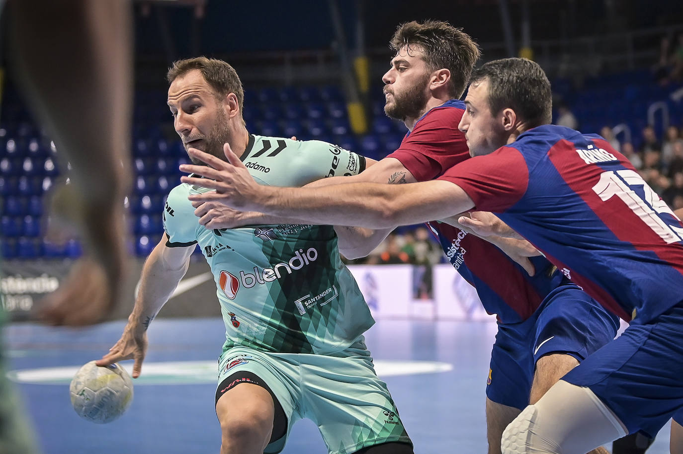 Tioumetsev pasa el balón ante la defensa de dos jugadores culés.