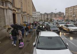 Varias familias llegan al colegio Salesianos, en General Dávila. Al lado de la entrada, una fila de coches mal estacionados.