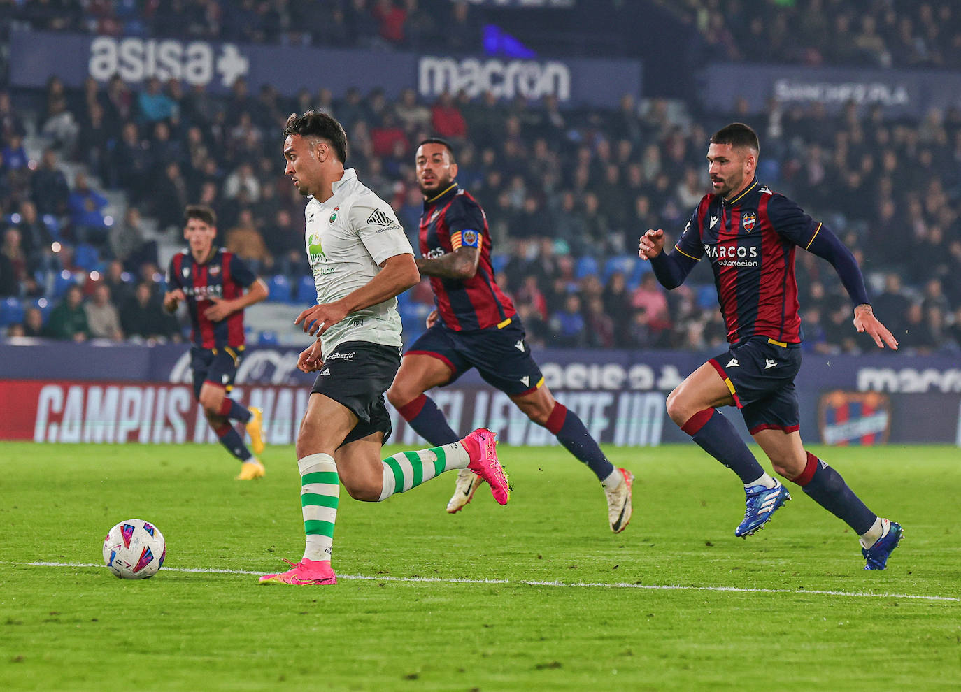 Arana, en plena carrera perseguido por dos jugadores del Levante. 