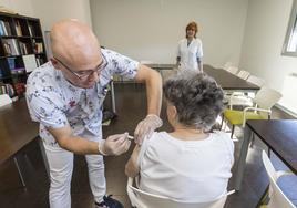 Un enfermero del centro de salud de El Sardinero pone la vacuna de la gripe a una mujer en la residencia Virgen del Faro.