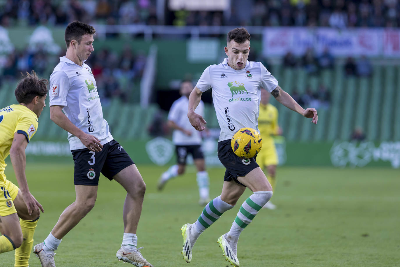 Íñigo Vicente controla un balón en presencia de Saúl García y del visitante Lanchi. 