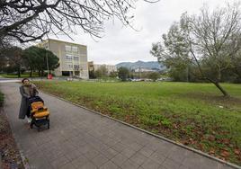 Una vecina camina junto a las fincas reservadas para la piscina olímpica, este otoño, en el entorno del campus de la UC.