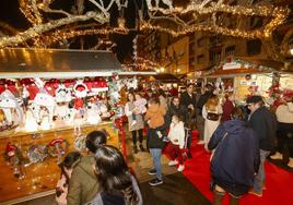 Vecinos visitan el Mercado de la Navidad ubicado en la Avenida de España, en Torrelavega