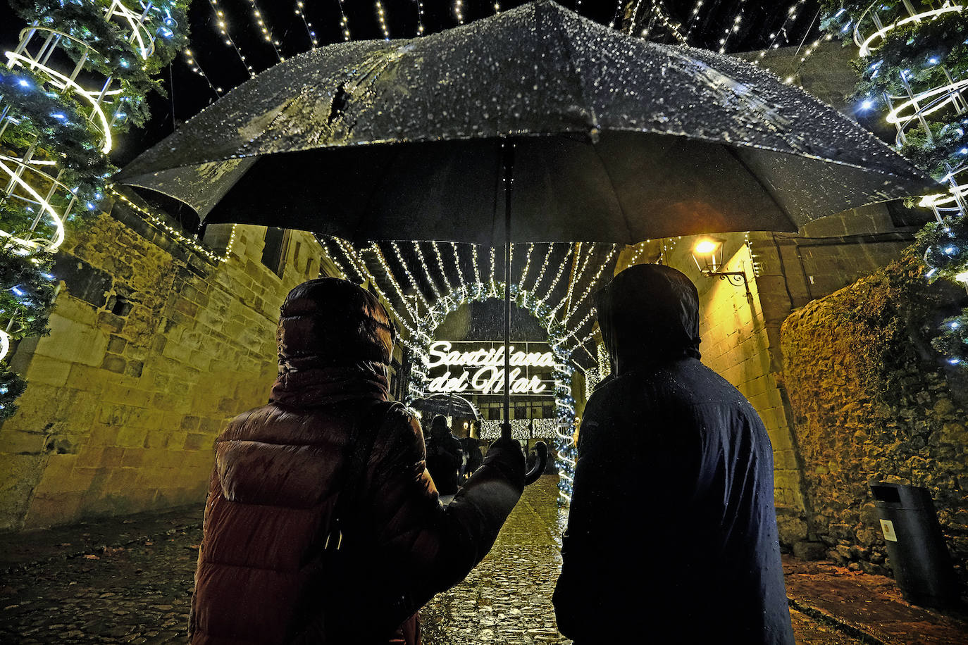 Dos vecinos de la villa a punto de cruzar el paseo de luces.