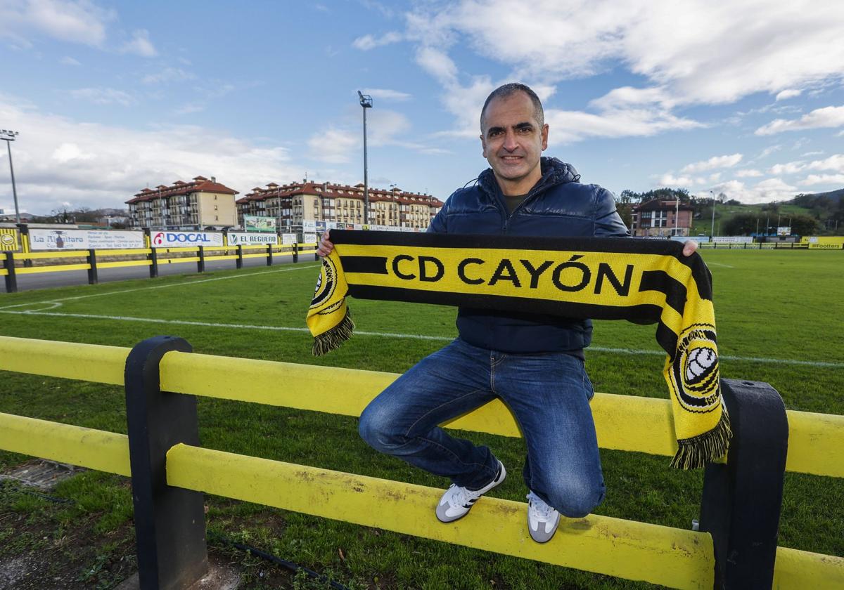 Javi Fernández posa en las vallas del Fernando Astobiza con una bufanda del Cayón.