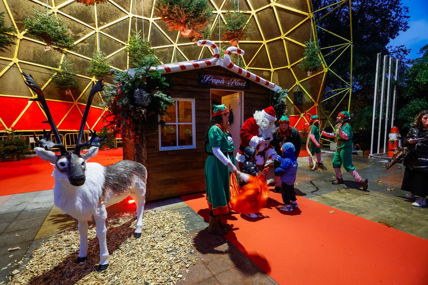 Papá Noel recibe a un niño, este lunes, durante la presentación de su cabaña en el auditorio Lucio Lázaro del parque Manuel Barquín.