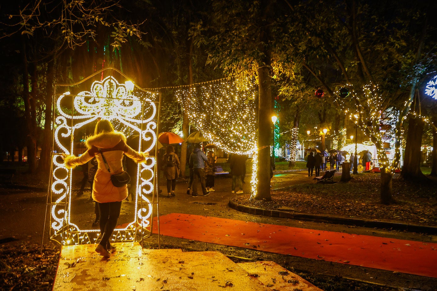 Una vecina posa en uno de los decorados del pulmón verde, iluminado con 100.000 bombillas. 