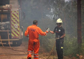 Un operario de Protección Civil y un bombero del 112 trabajan en un incendio.