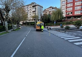 Los sanitarios atienden a la mujer herida en el lugar del accidente, donde se observa la motocicleta en la que viajaba.