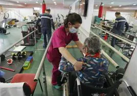 Una terapeuta ayuda a una mujer en el centro hospitalario Padre Menni