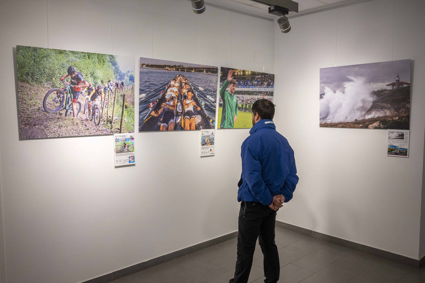 Un joven se detiene a observar fotografías de eventos deportivos.