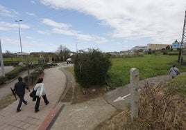 Vecinos caminan por el entorno donde se proyectan 457 viviendas, en El Valle (Torrelavega).