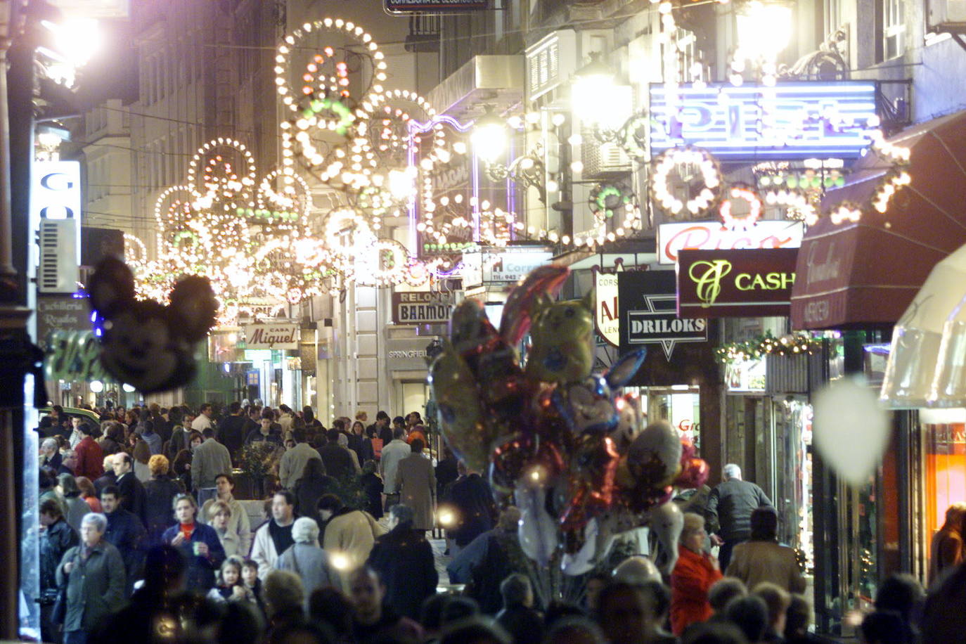 Actividad comercial en una calle repleta de gente en Navidad.