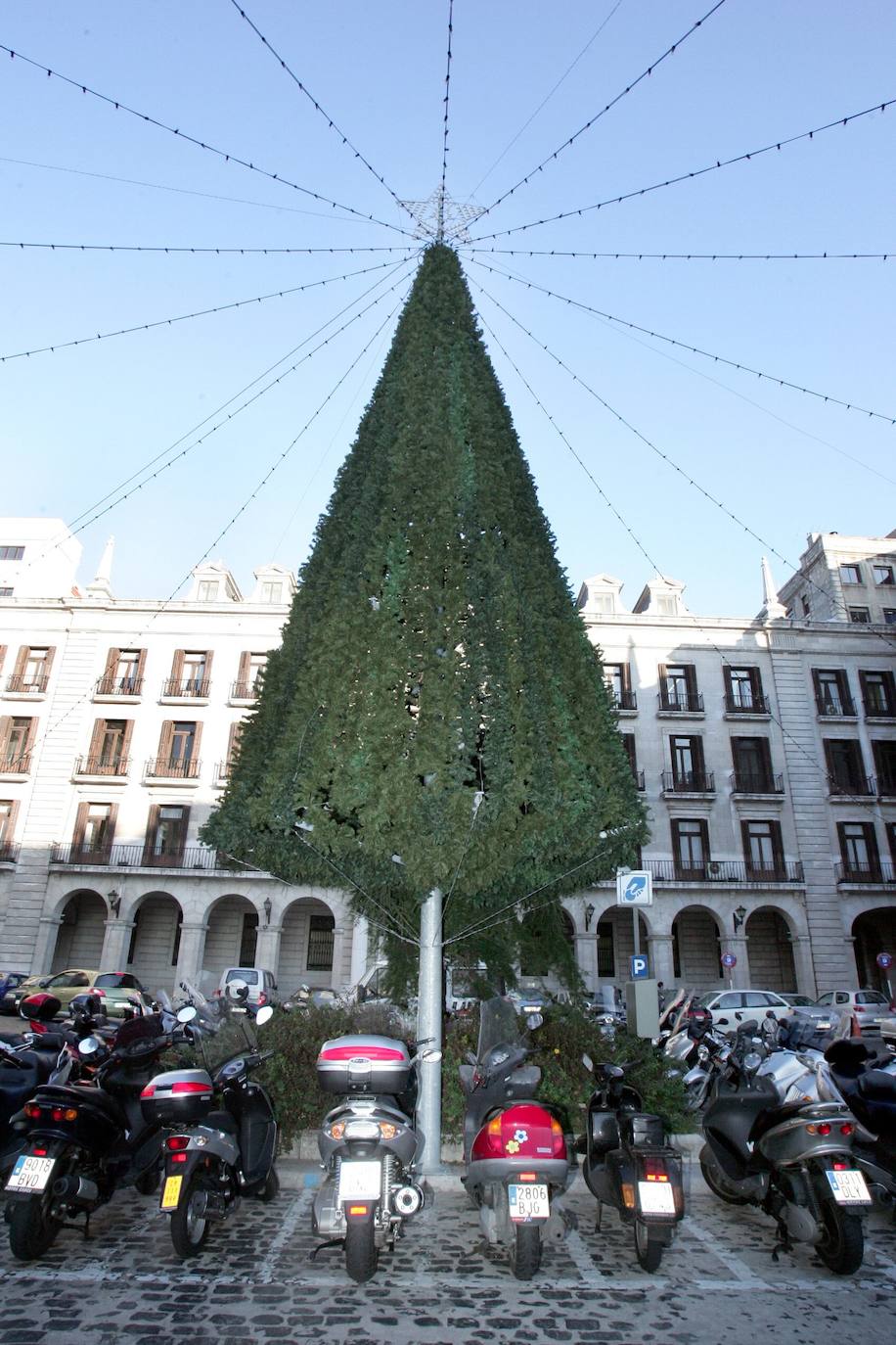 Árbol navideño en medio de la Plaza Porticada de Santander hace 18 años, rodeado de motos y coches porque todavía se podía aparcar en el interior.