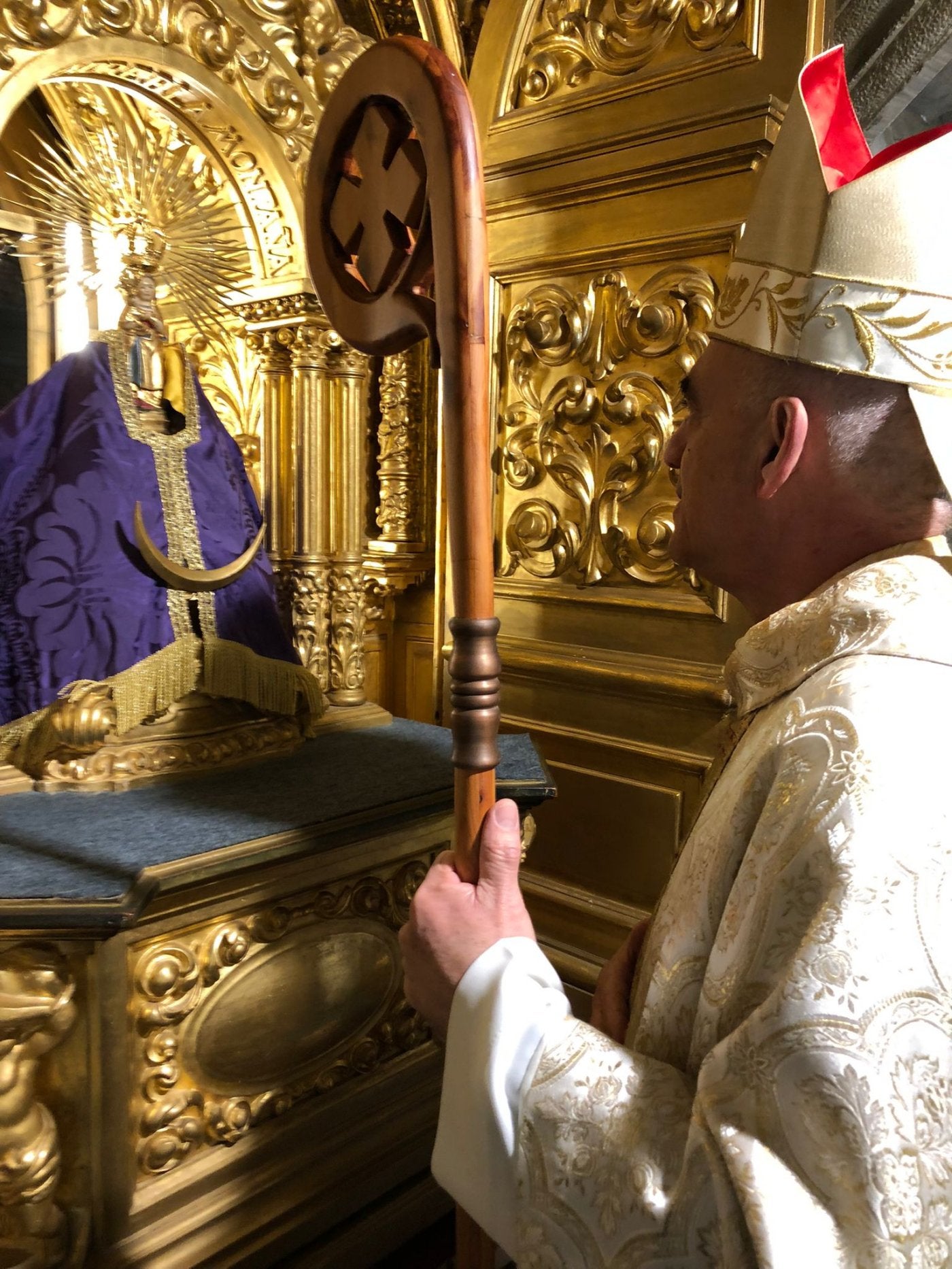 El obispo orando, ayer, ante la Patrona de Cantabria.