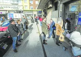 Un grupo de personas hace cola frente a la administración número 8, junto a la plaza de las Estaciones de Santander.