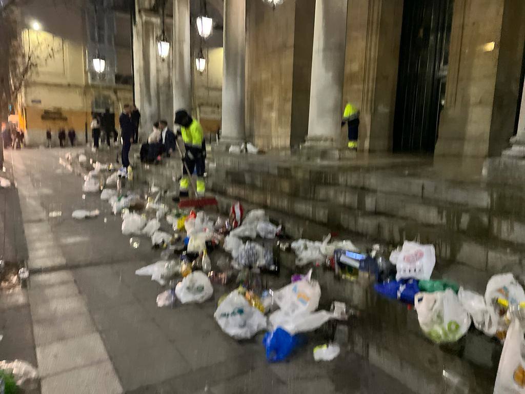 Operarios del servicio de limpieza de Santander recogen la basura en la entrada la iglesia de Santa Lucía.