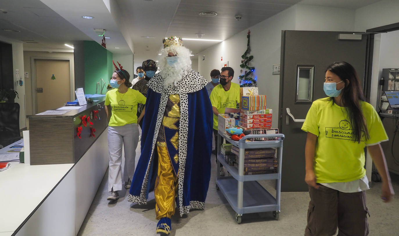 Melchor, en primer plano, llega a la planta de Pediatría de Valdecilla, acompañado de los voluntarios de la asociación Buscando Sonrisas.