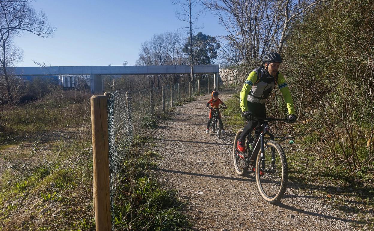 Un ciclista y su hijo circulan por las inmediaciones de las nueva pasarela peatonal. 