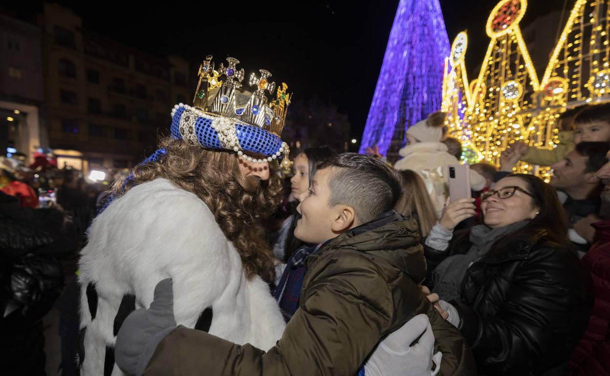 Un niño abraza al Rey Gaspar.