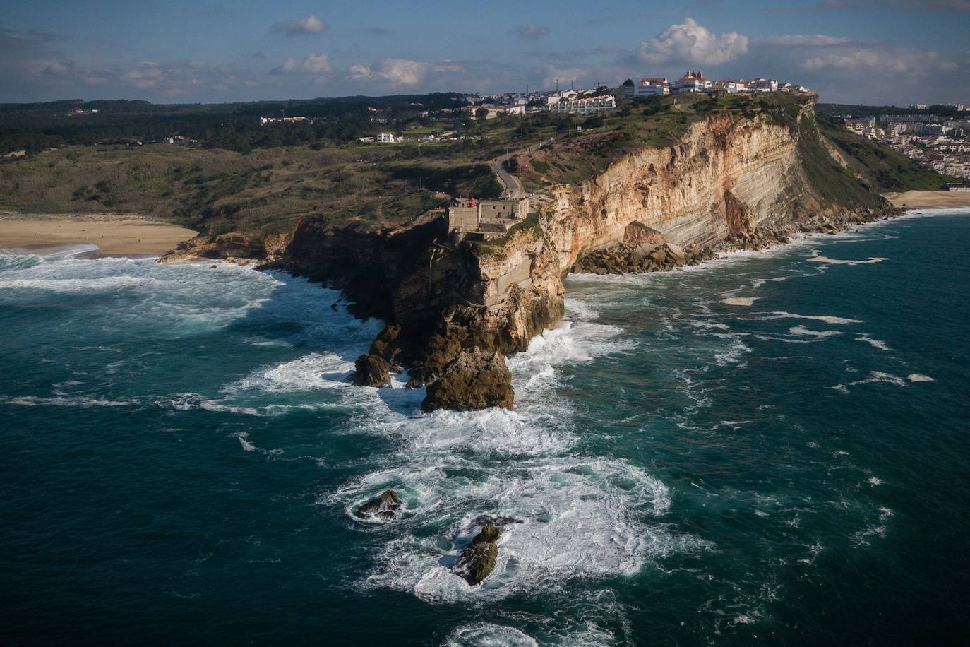 La naturaleza es tan bella como peligrosa. La magnitud de las populares olas de esta zona de Portugal son la mejor prueba de ello. El mar se rompe con un impresionante oleaje que atrae a surfistas y curiosos hasta esta aldea de pescadores, conocida por las olas enormes que se cobraran la vida del surfista brasileño Marcio Freire el pasado 6 de enero.