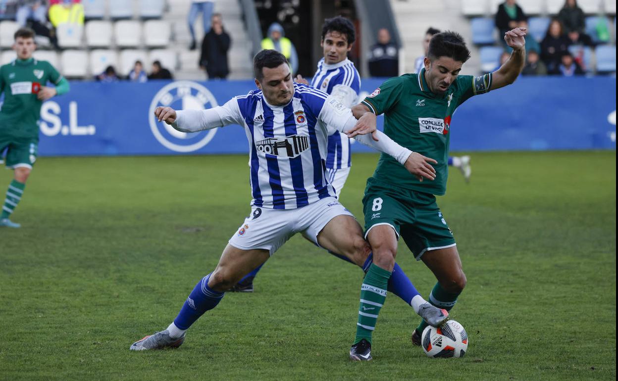 Tobar trata de arrebatar el balón a De Vicente.