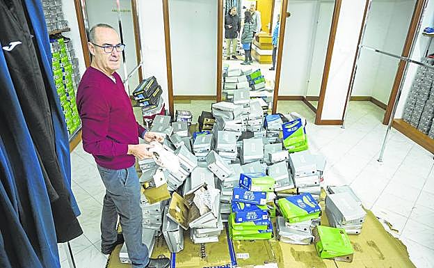 Antonio López, de Deportes Record (Laredo), recoge el calzado destrozado esta semana por el agua. 