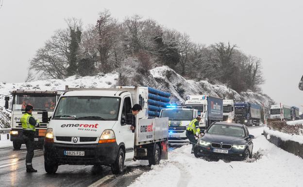 La Guardia Civil de tráfico retira a un coche atrapado en la nieve en la A-67, a la altura del Hayal, antes de llegar a Reinosa.