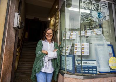 Imagen secundaria 1 - La administración número 13 de Loterías sigue hoy prácticamente igual que cuando se inauguró. Los rótulos, los cristales y los marcos son los originales, aunque el cartel más grande está actualmente cubierto con el oficial de Loterías del Estado. En la foto de arriba, Olga Gutiérrez, quien gestiona ahora el negocio con su socia Teresa Gajano.