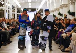 Tres niños durante el desfile solidario, en el Hotel Real, con tablas de snow y ropa de nieve de la firma Obsession.