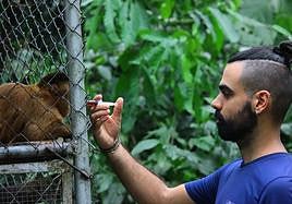 El biólogo cántabro Iván Márquez da una medidina a un mono capuchino en el Amazonas.