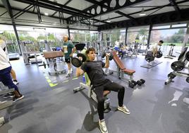 Un joven levanta pesas en el gimnasio BeOne Fitness, de Cabezón de la Sal.