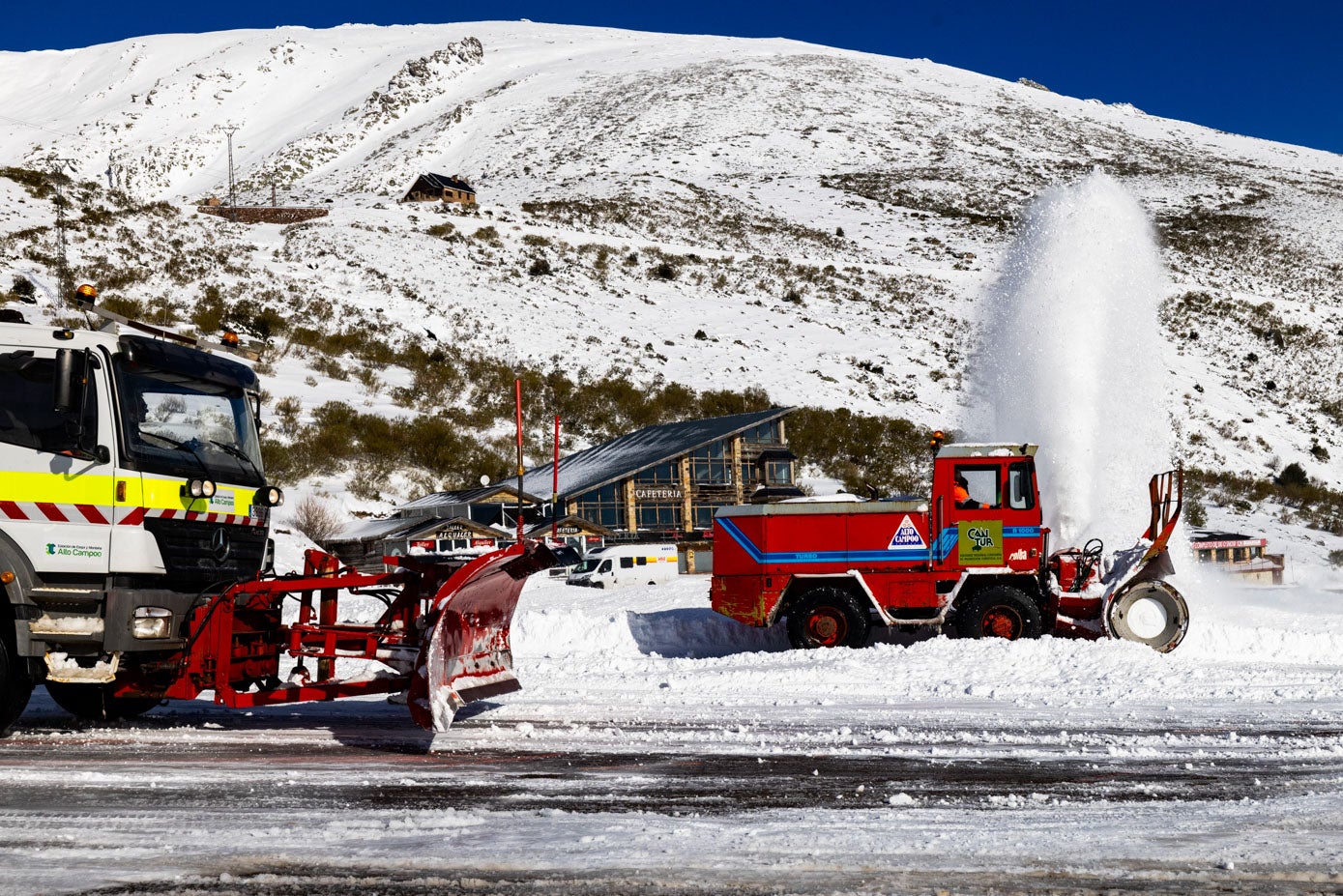 Una fresadora y un camión-cuña despejan de nieve el aparcamiento principal.