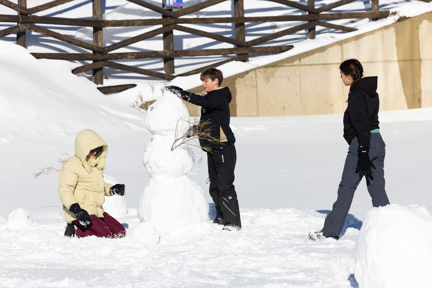 Tres niños hacen un muñeco de nieve, este lunes, en Alto Campoo.