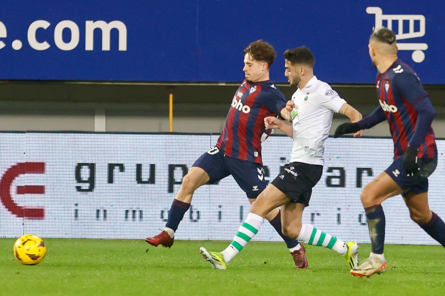 Mario Soriano, del Eibar, pelea con Andrés Martín, del Racing, para llegar al balón. 