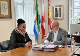 Rosalina López Visitación firma el pacto con el alcalde de Laredo, Miguel González.