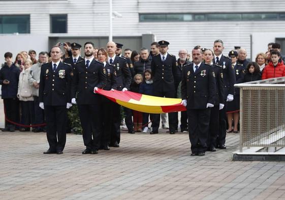 Los agentes trasladas la bandera para su izado.