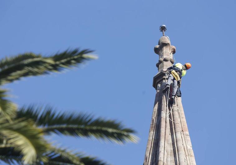 Un operario encaramado a la torre para cambiar el pararrayos.