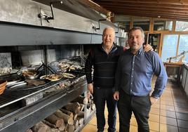 Manolo Blanco y su hijo Manuel, junto a la parrilla donde las brasas hacen el 'milagro' con carnes y pescados.