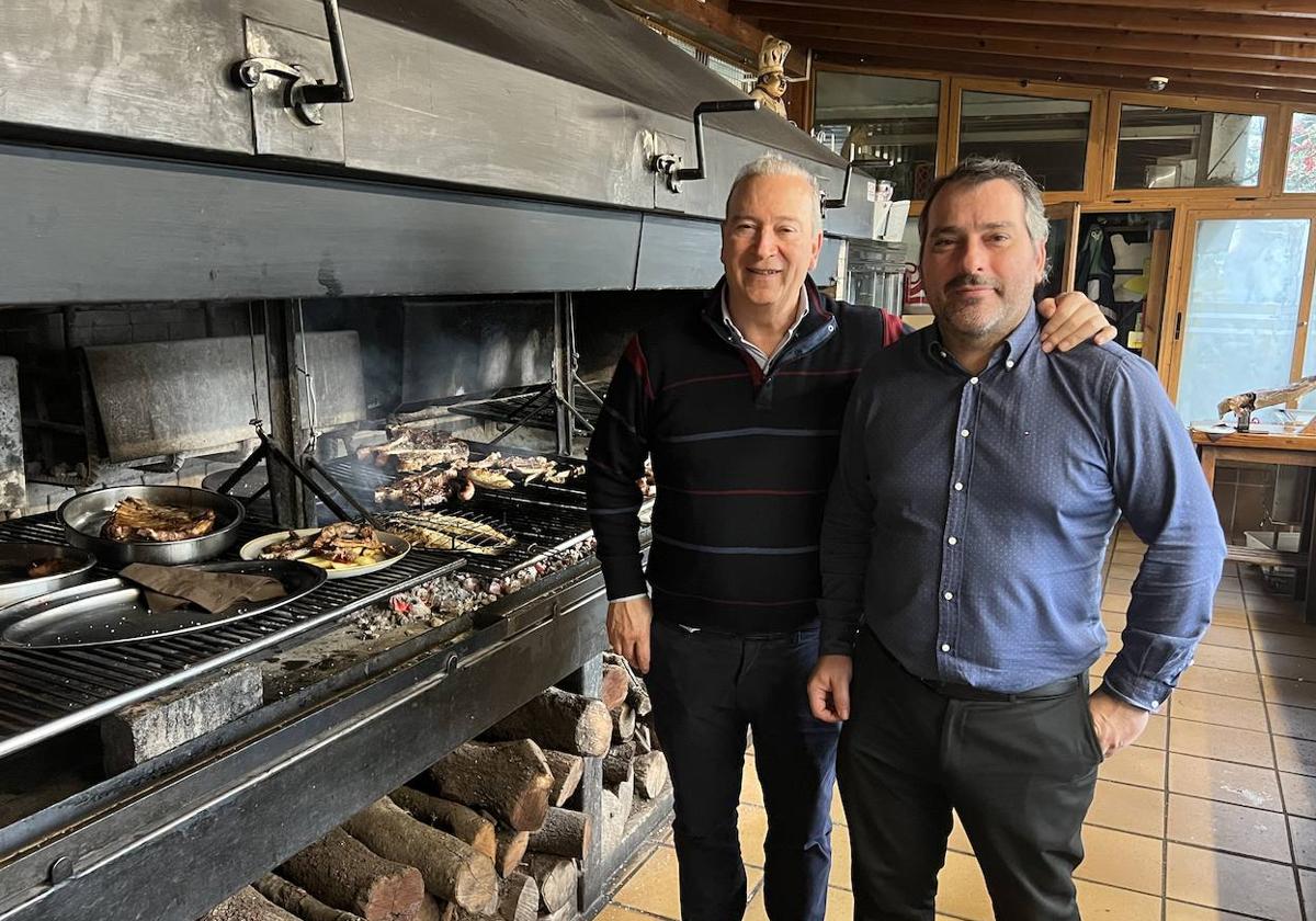 Manolo Blanco y su hijo Manuel, junto a la parrilla donde las brasas hacen el 'milagro' con carnes y pescados.